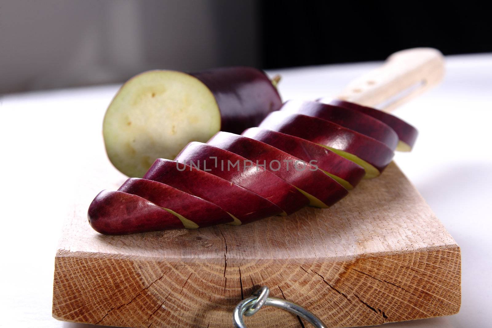 Eggplant sliced on a wood cutter and knife