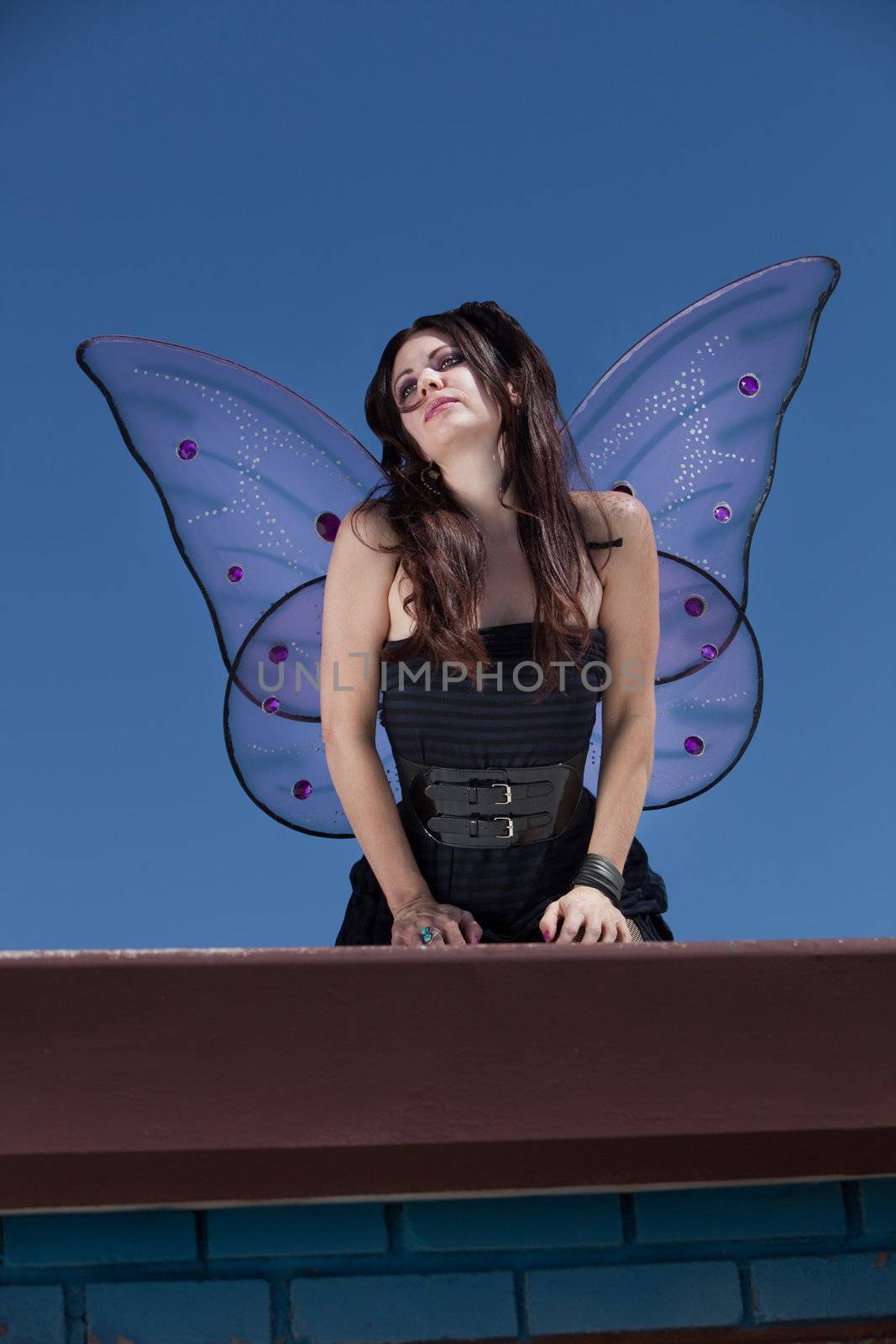 Faery looks out while standing outdoors on a rooftop