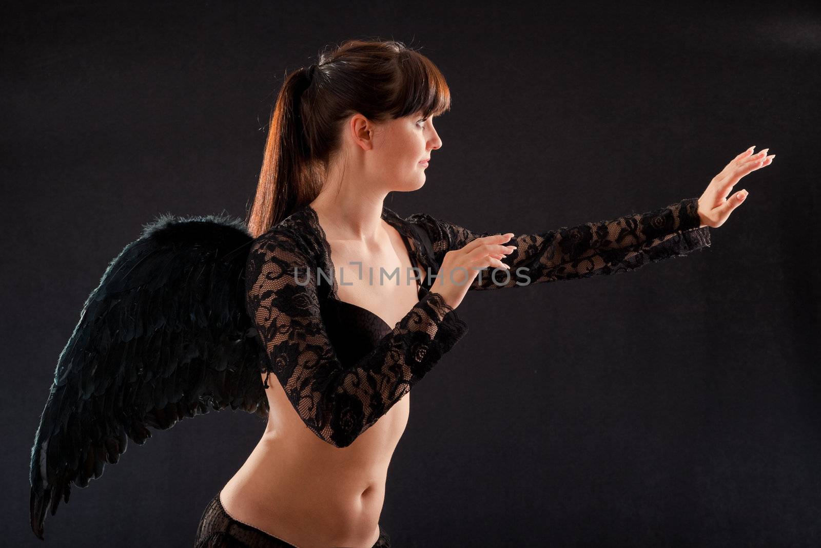 girl in black underwear and black wings on a black background