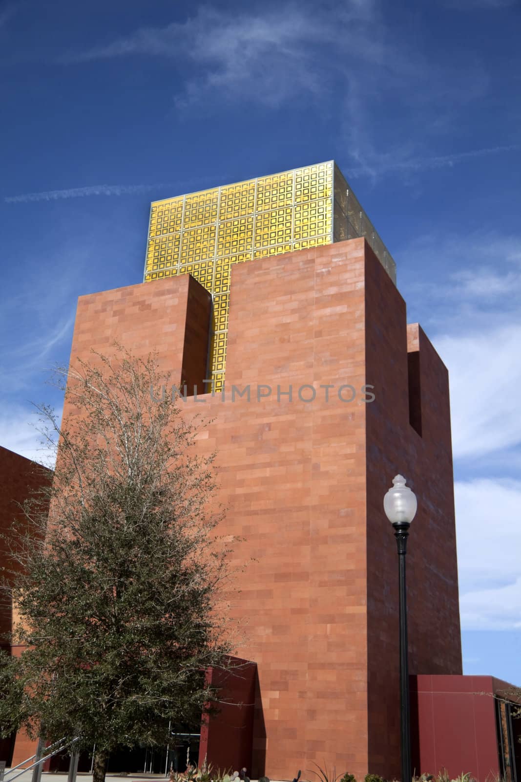 A modern brick building entrance with yellow glass and light pole