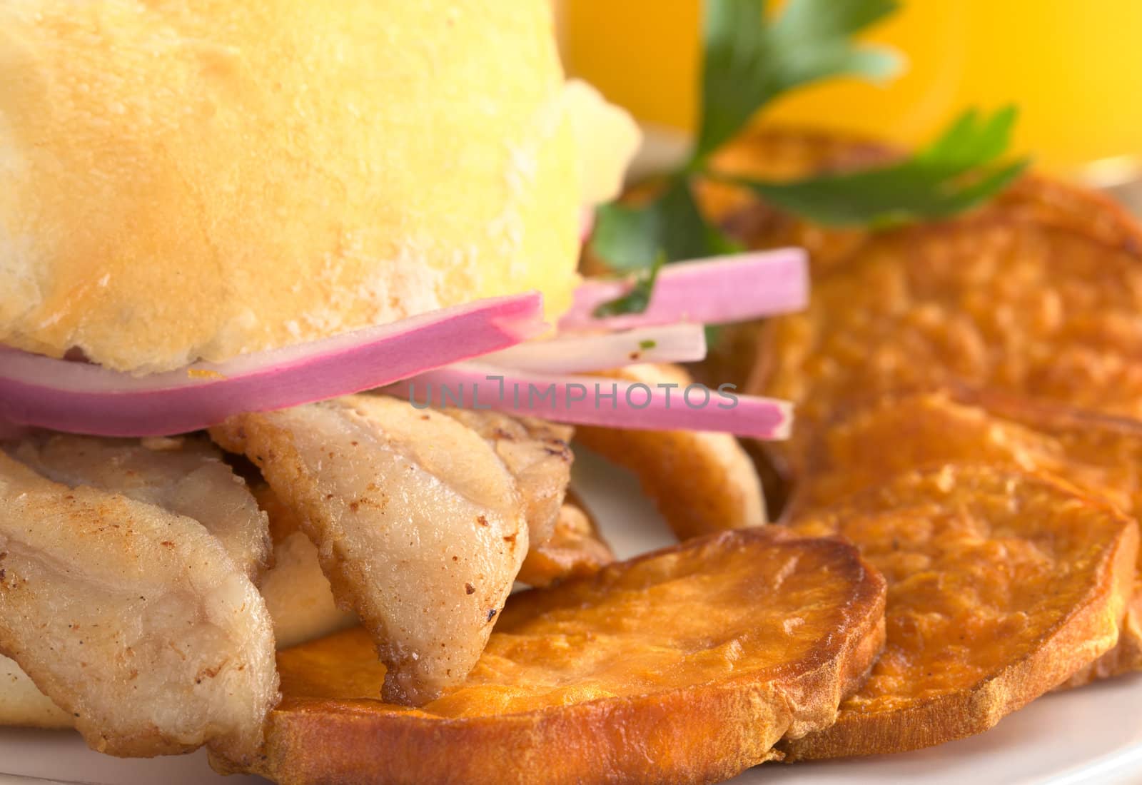 Peruvian sandwich called Pan con Chicharron which is traditionally eaten for breakfast, and is prepared with fried pork and sweet potato and filled with ketchup and onions (Selective Focus, Focus on the front of the right meat) 