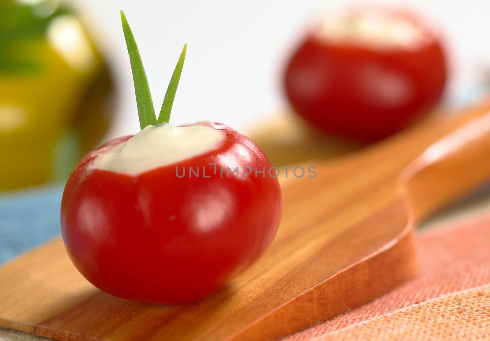 Small round hot red pepper filled with sour cream and garnished with chives on spatula (Very Shallow Depth of Field, Focus on the chives)