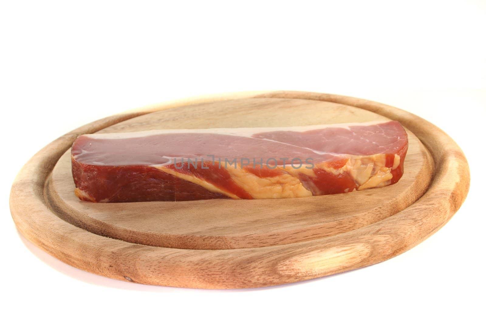 smoked bacon on a wooden board before a white background