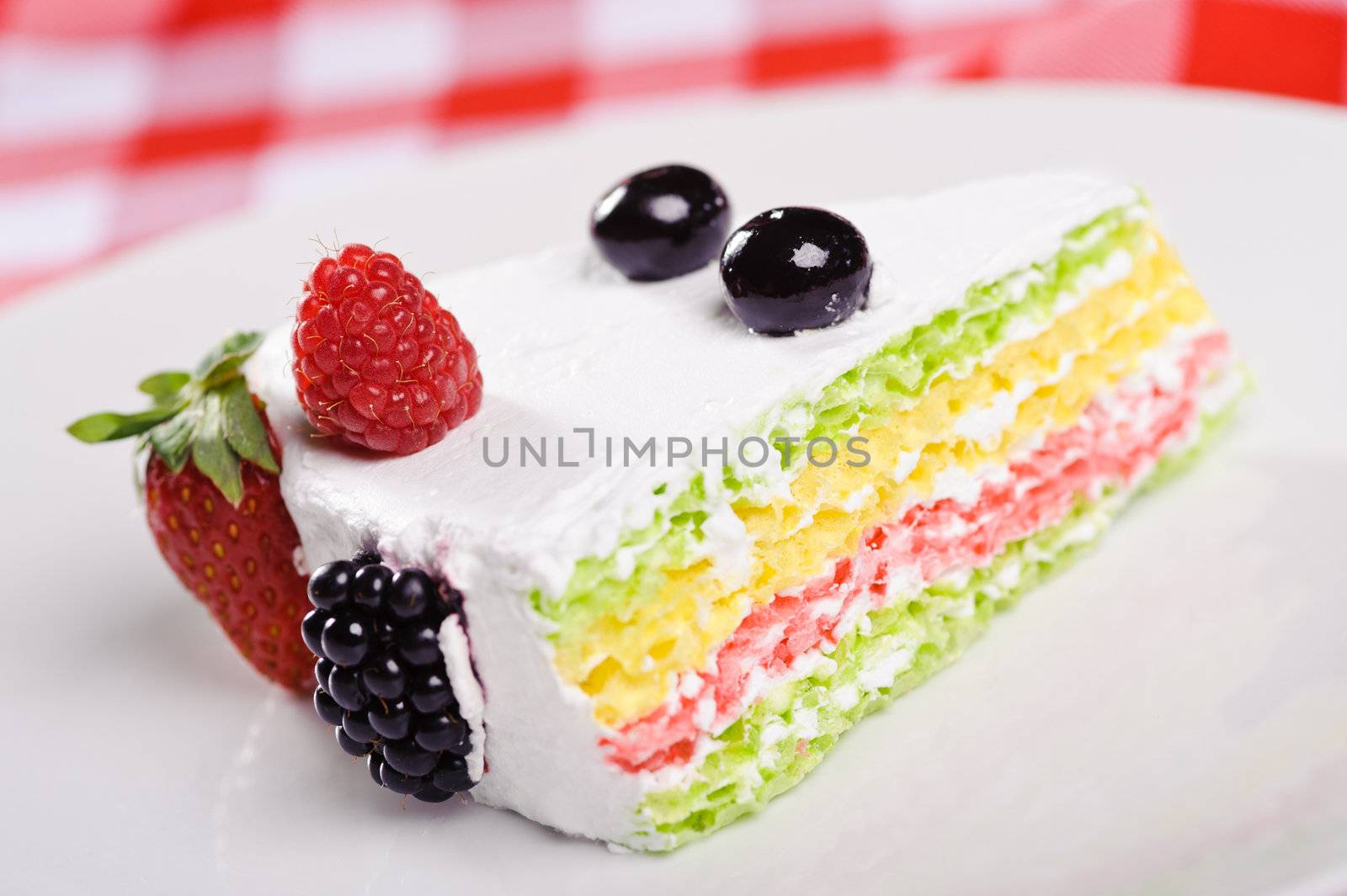 Piece of cake on plate with berries and fruits