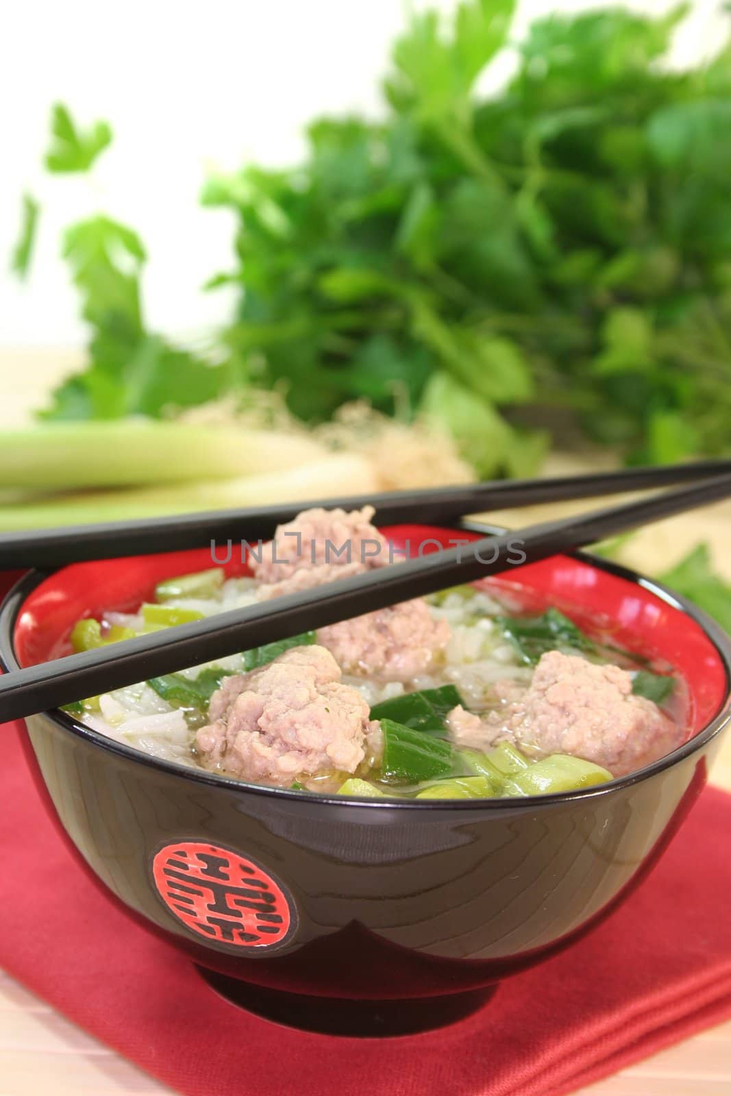 Thai rice soup with meat balls, rice and spring onions
