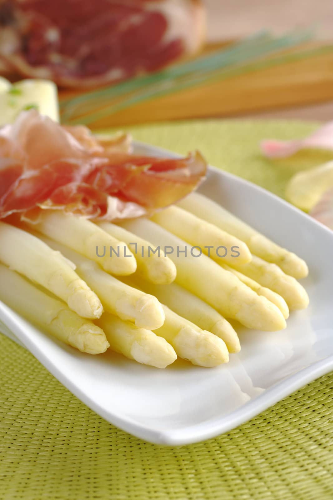 Fresh cooked white asparagus served with ham (Selective Focus, Focus on the front of the asparagus on the left)