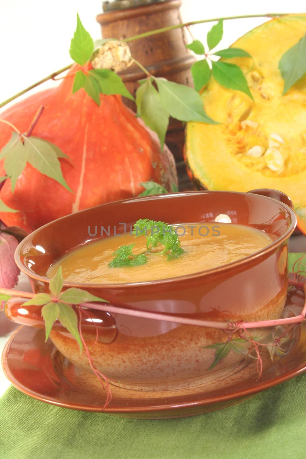 Pumpkin cream soup with fresh Hokkaido pumpkin and autumn leaves