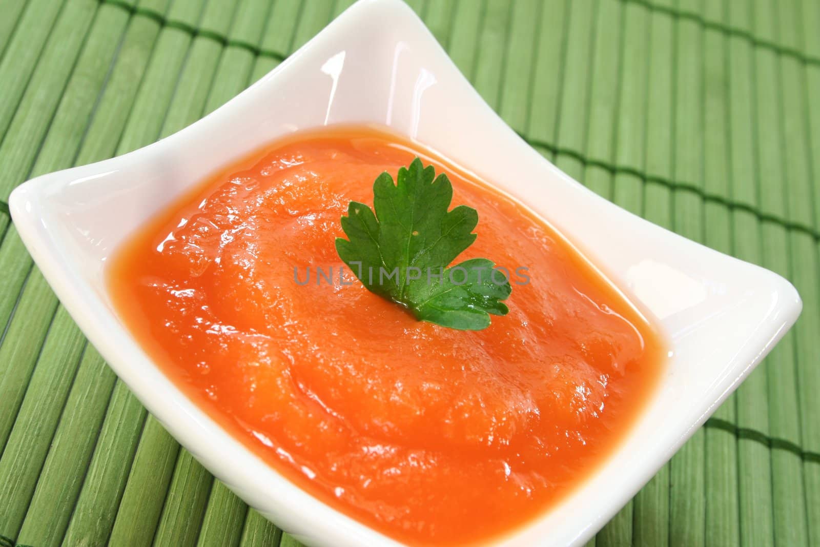a bowl of carrot soup with fresh parsley