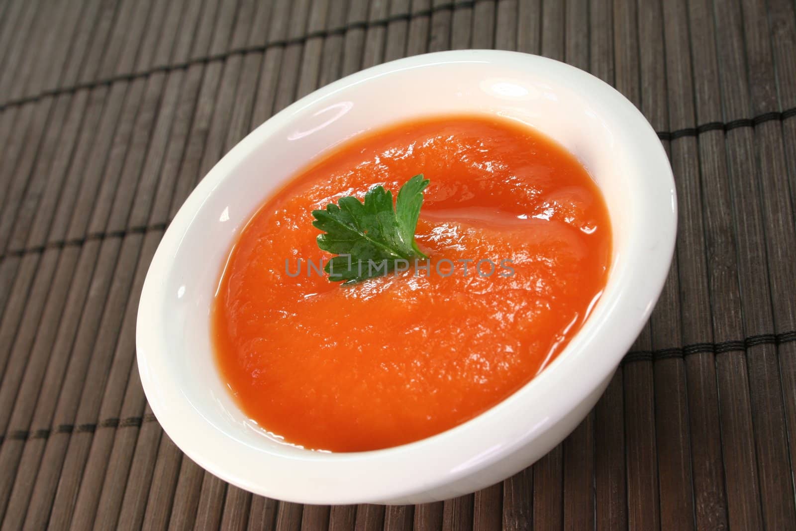 a bowl of carrot soup with fresh parsley