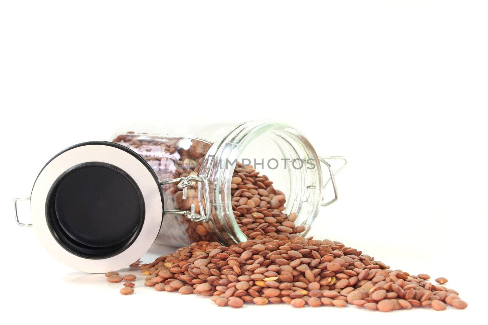 dried lentils in a glass on a white background