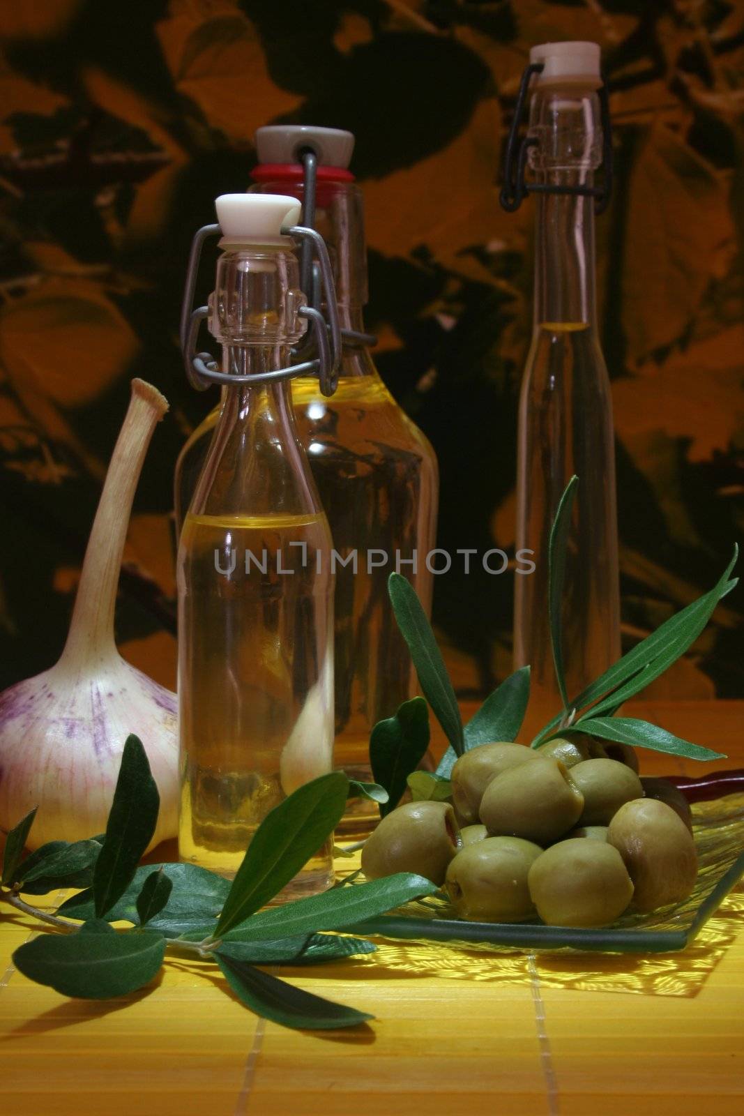 Olive oil with olive branch and fresh olives and garlic