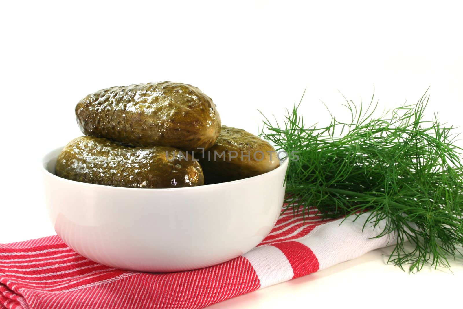 fresh pickled cucumbers with a sprig of dill in a bowl