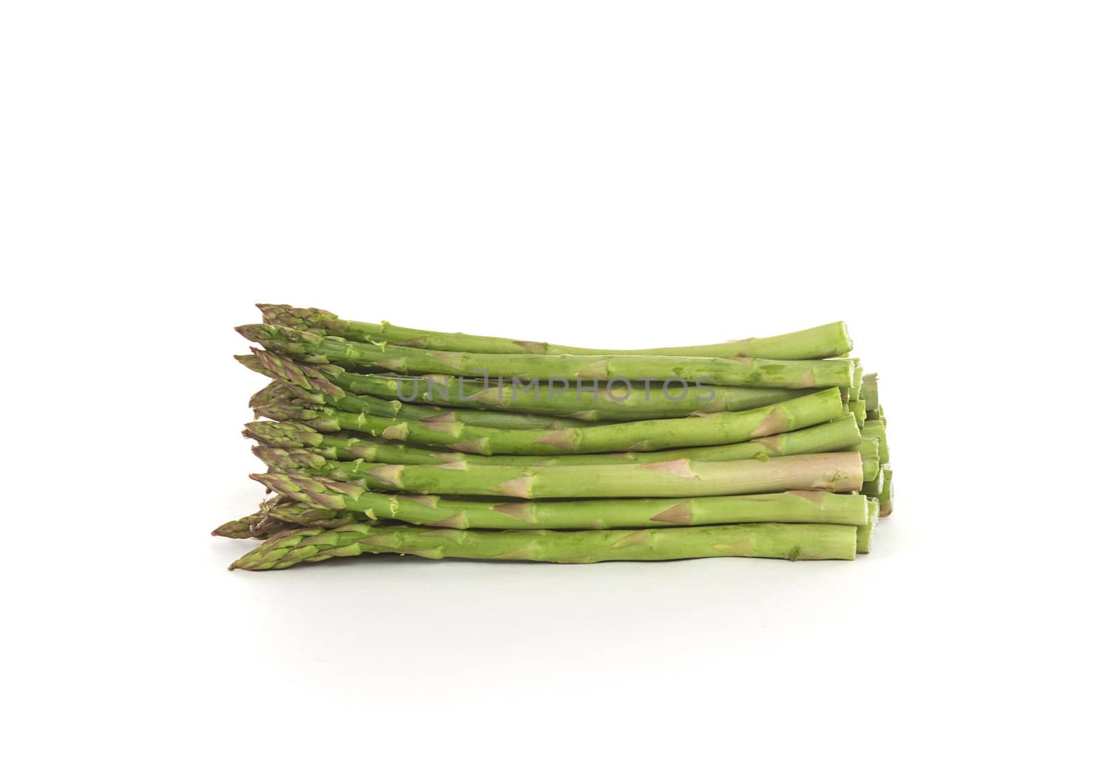 Fresh raw green asparagus bunch lying on white 