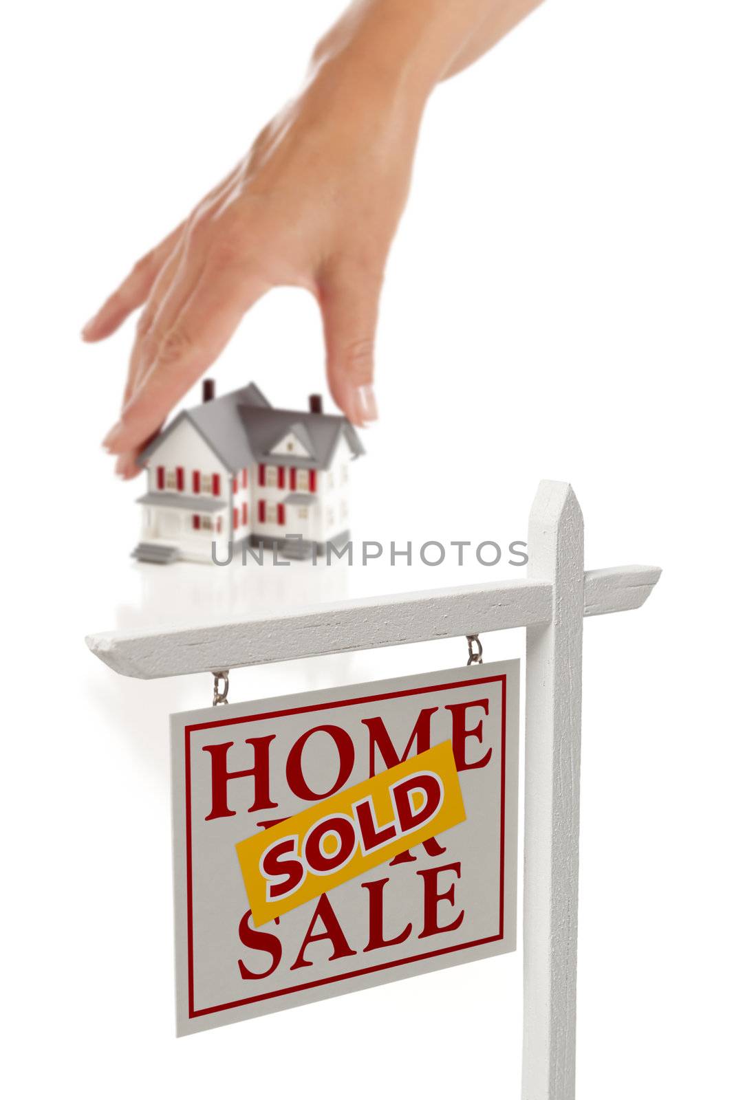 Womans Hand Choosing Home with Sold Home For Sale Real Estate Sign in Front Isolated on White.