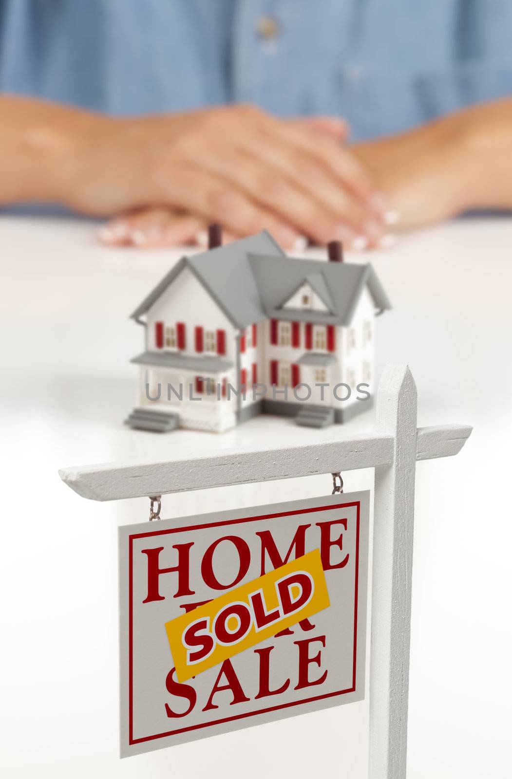 Womans Hands Behind House and Sold Real Estate Sign by Feverpitched