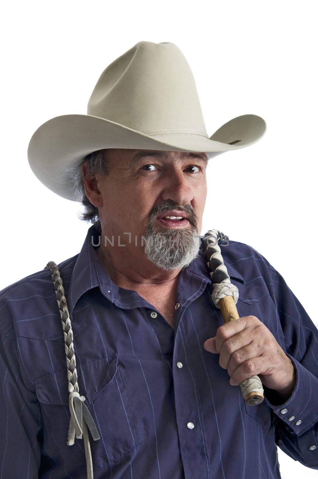 Cowboy holding a bullwhip around his shoulder. Isolated on white