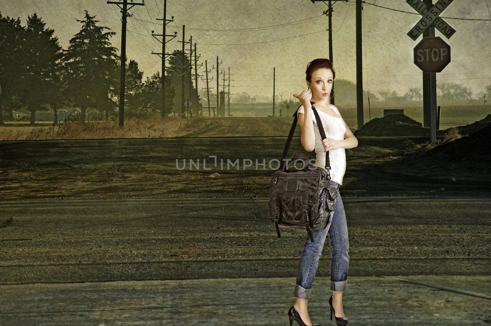 Sexy young redhead hitchhiking on a lonely country road. Composite