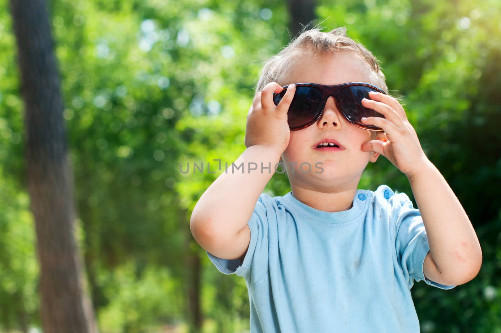 Cute 2 years old boy outdoors at sunny summer day