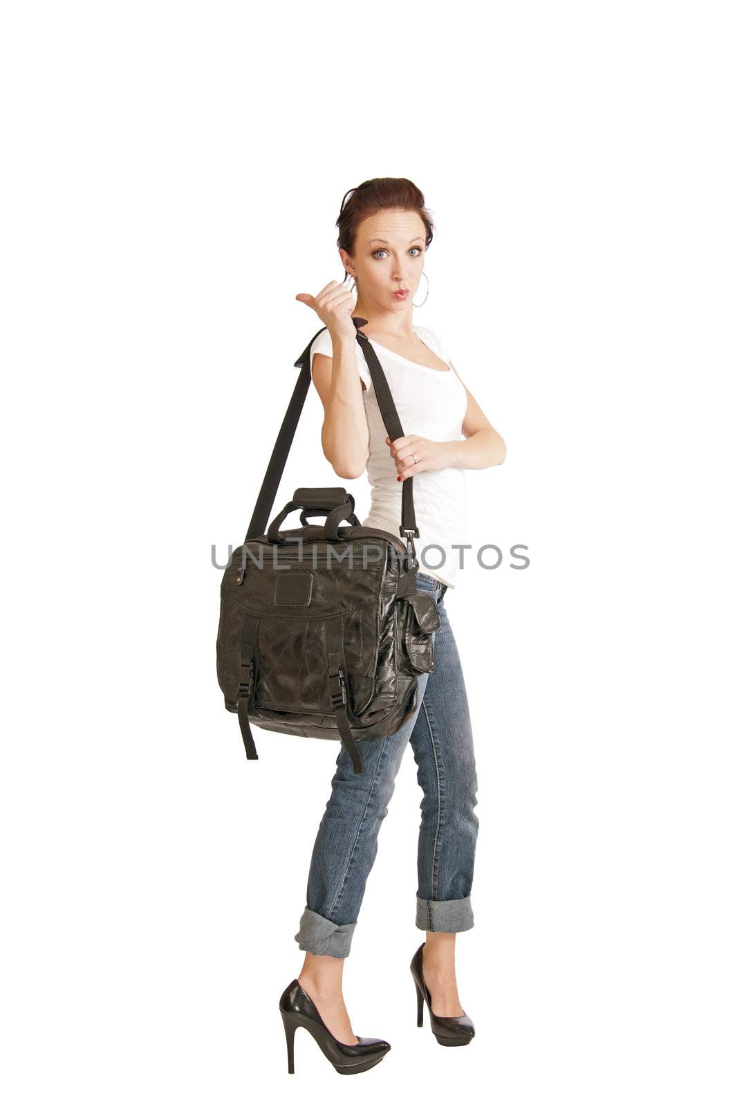 Pretty redhead girl in her 20's hitchhiking with a bag hanging from her shoulder.