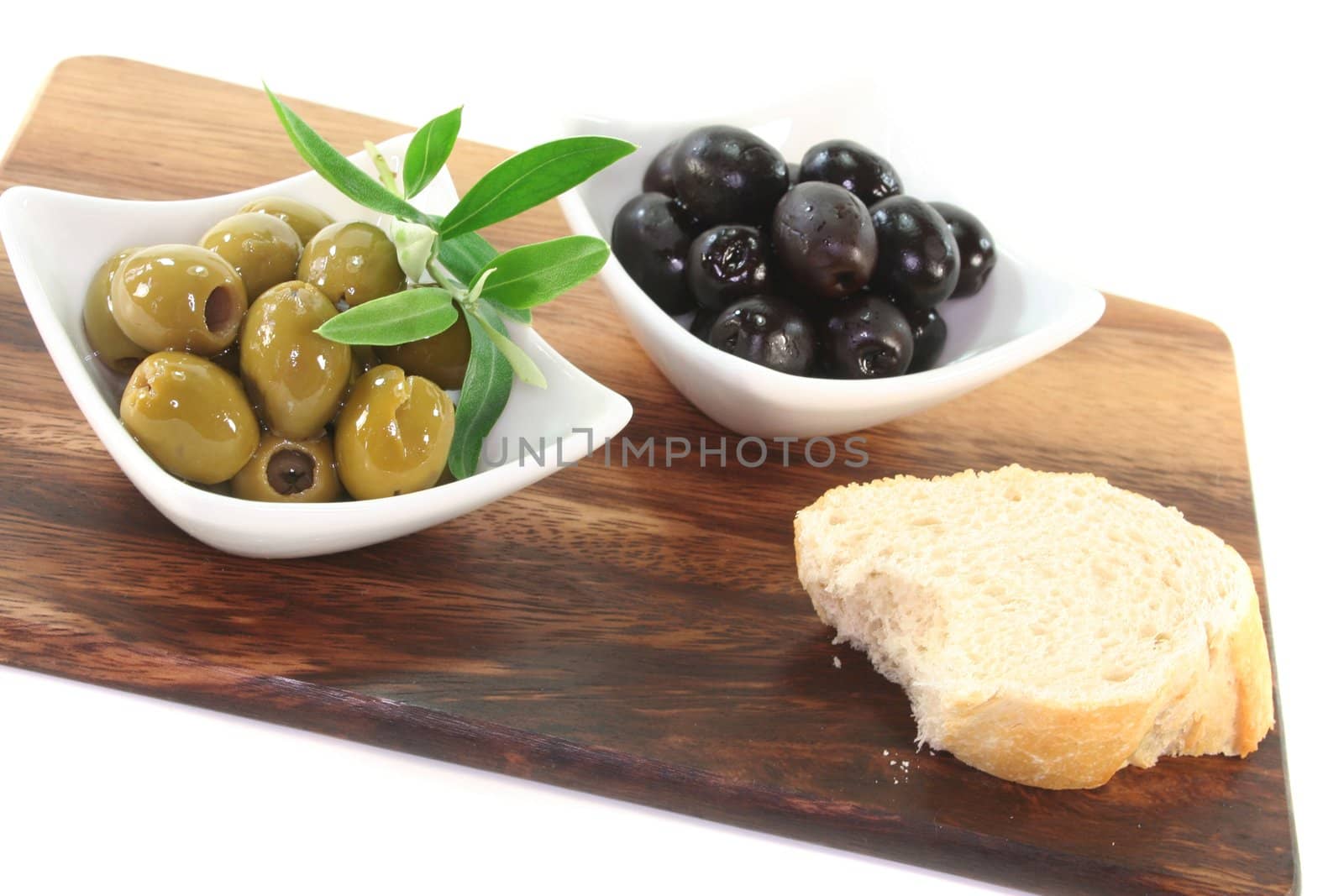 black and green olives with olive branch on a wooden board