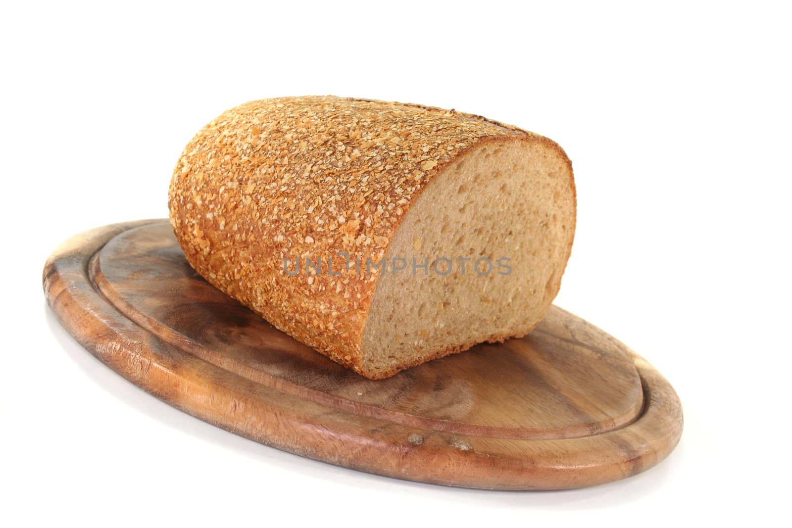 a crusty loaf of bread on a wooden board on white background