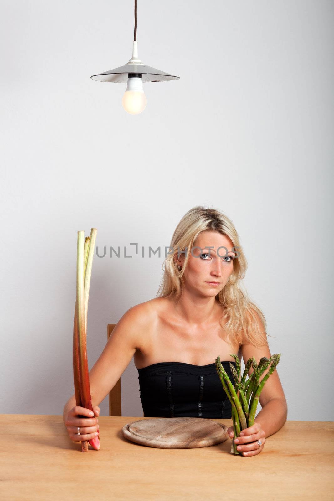 young woman sitting with rhubarb and asparagus by bernjuer