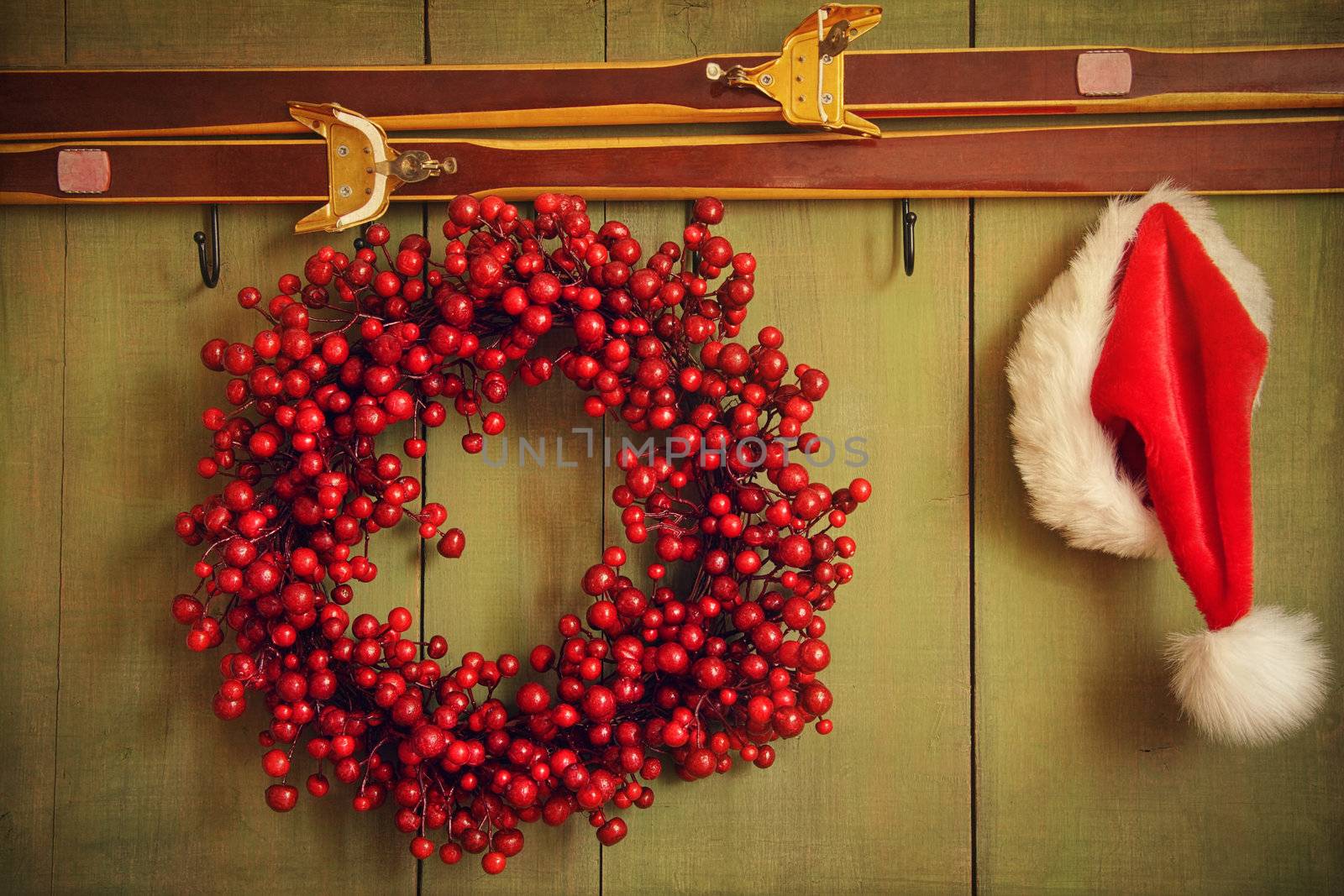 Red wreath with Santa hat hanging on rustic wall by Sandralise