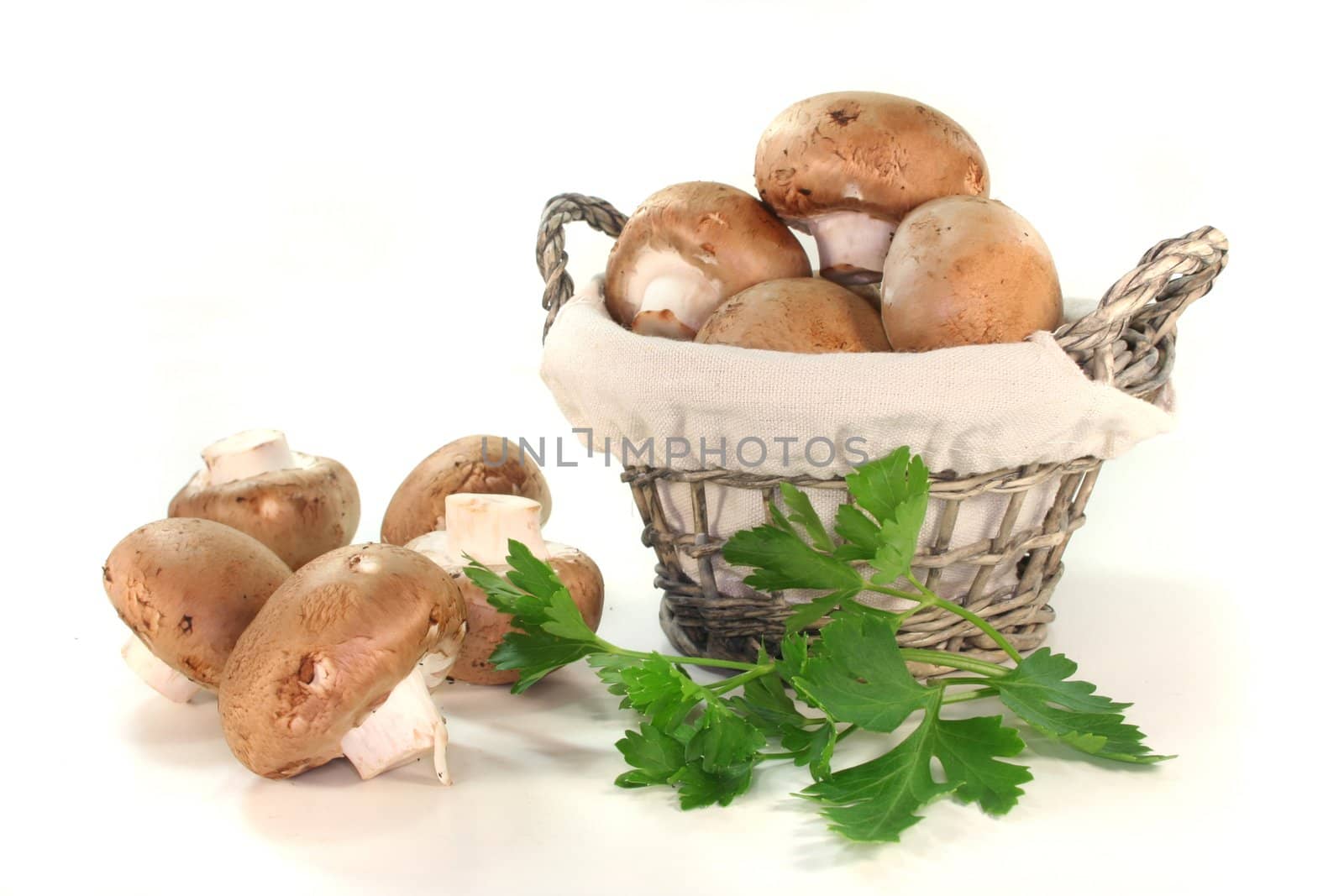 Mushrooms in a basket with parsley on a white background
