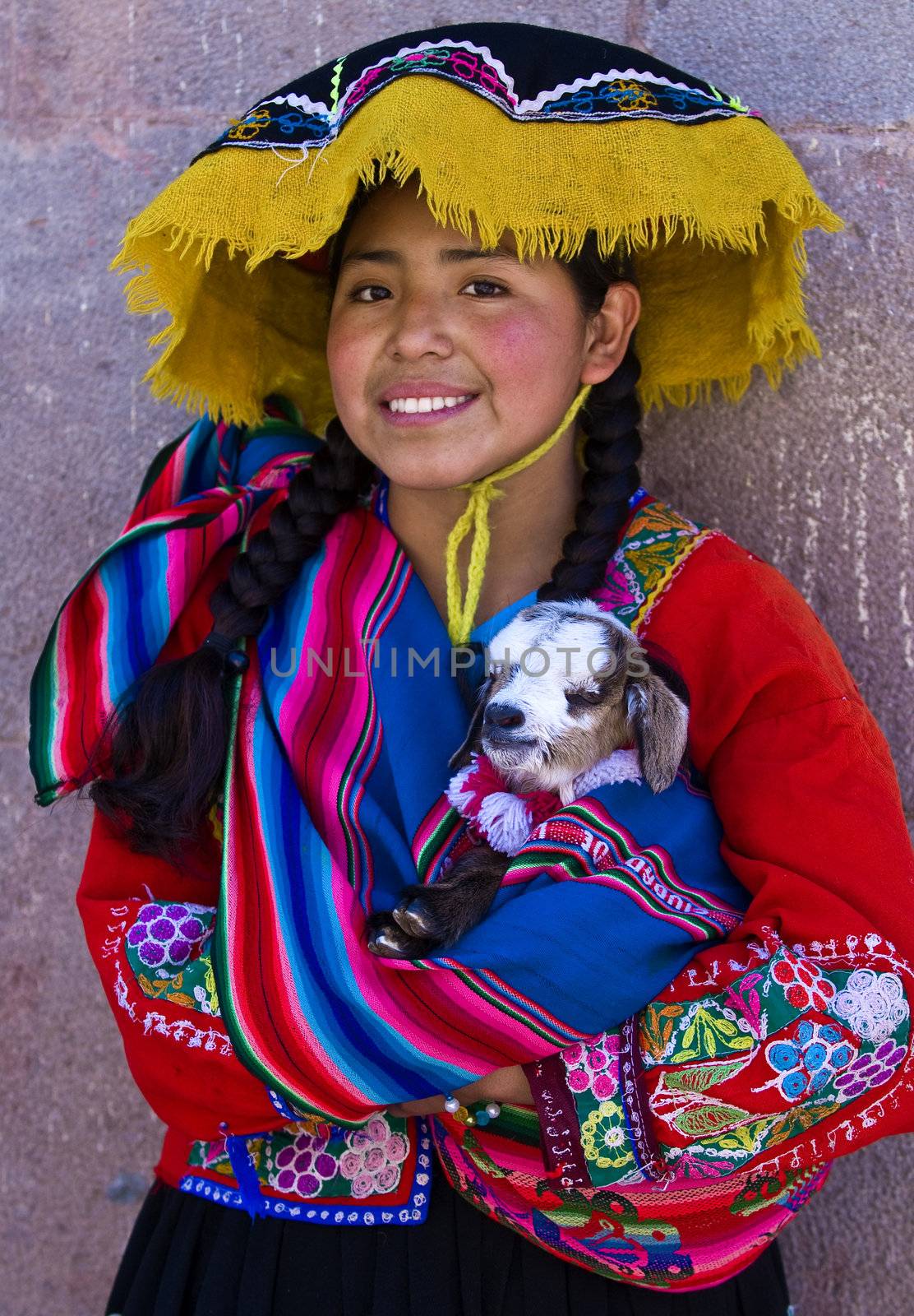CUSCO , PERU - MAY 28 : Unidentified Peruvian girl in traditional colorful clothes holding a lamb in here arms in the " Unesco world heritage" city "Cusco" on May 28 2011