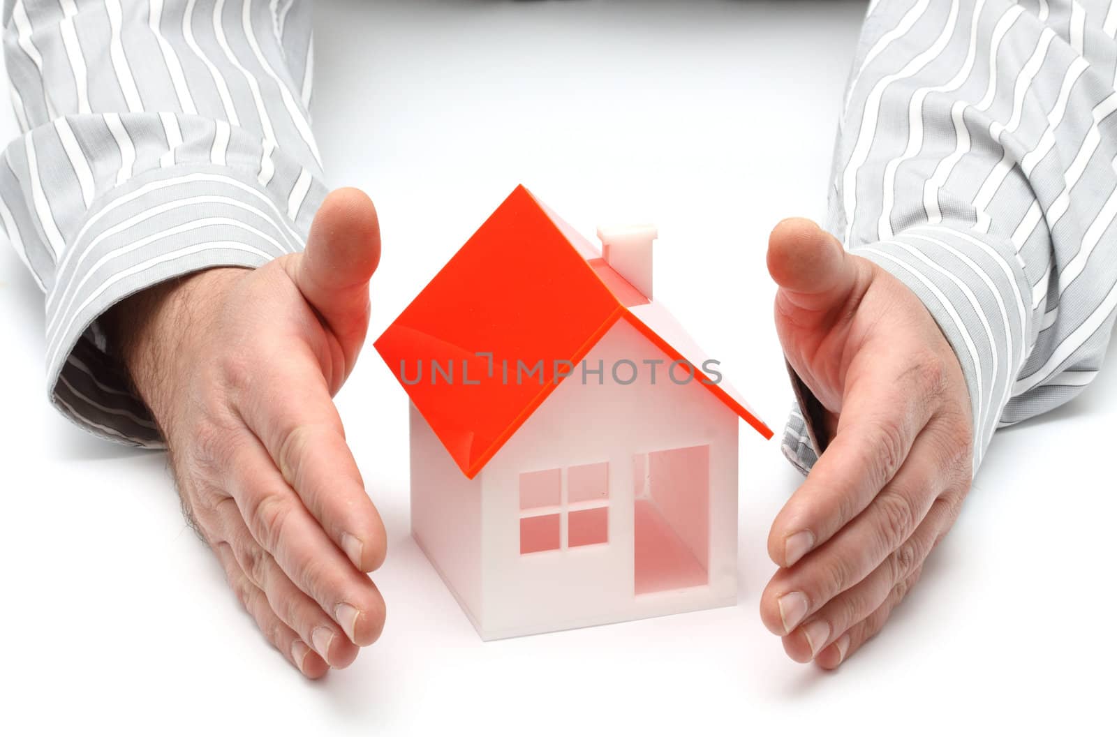 Hands and house model. Real property or insurance concept 