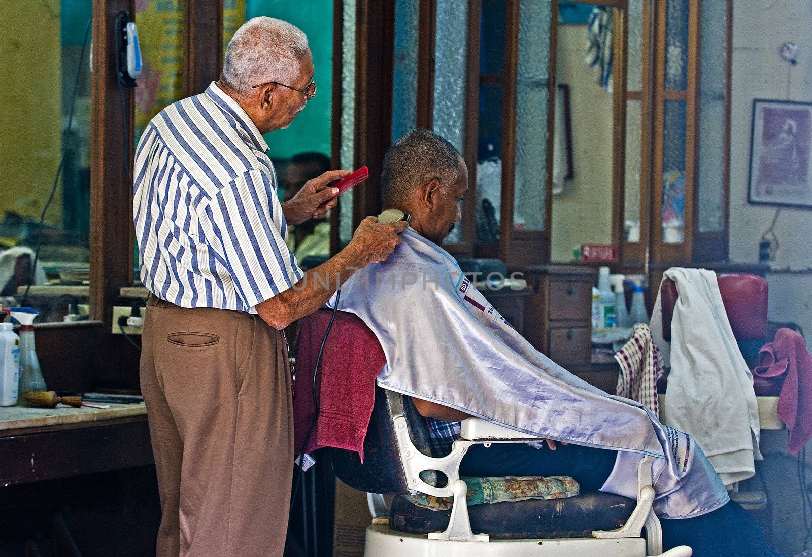 Caragenas de Indias , Colombia - December 21 2010 : Colombian man getting his hair cut in an old fashioned barber shop