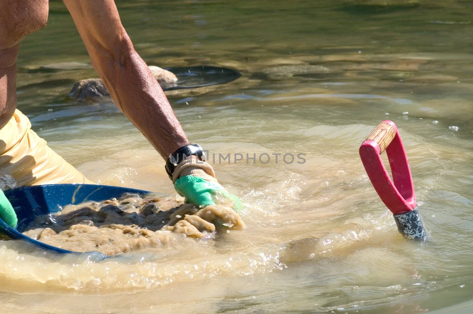 prospector panning for gold in river by gillespaire