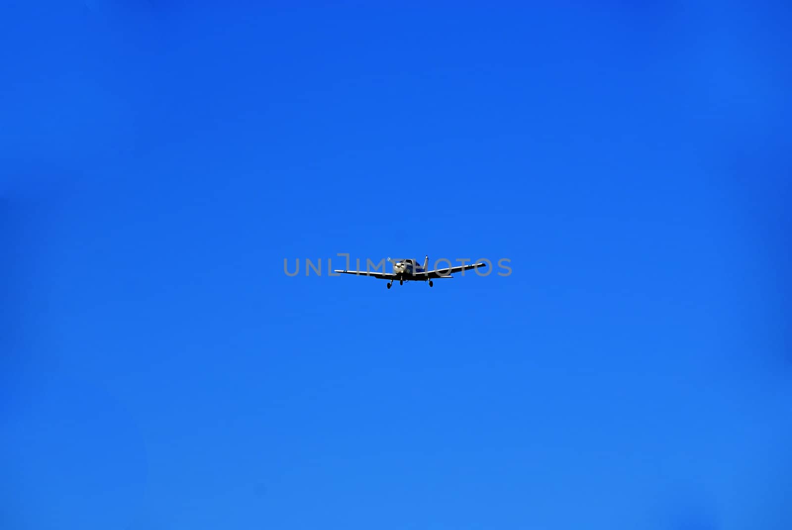A trainer glider plane isolated against a clear blue sky