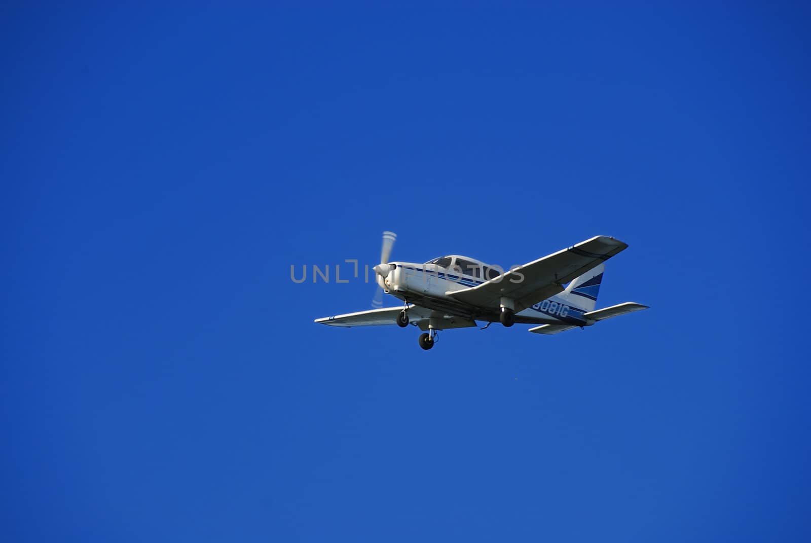 A trainer glider plane isolated against a clear blue sky