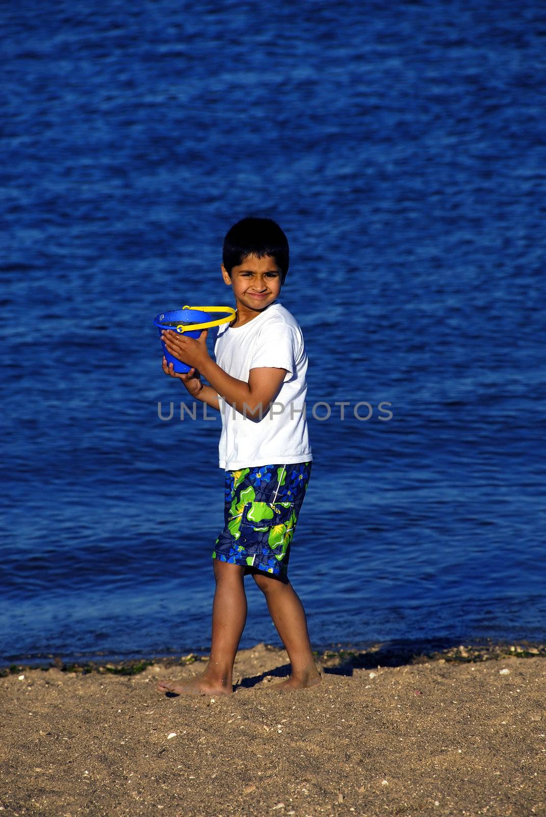 An handsome indian boy playing at the beach