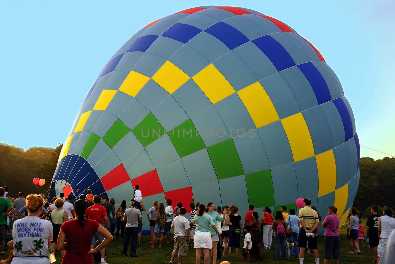 Recently landed hot air balloons and swarm of people watching it.
