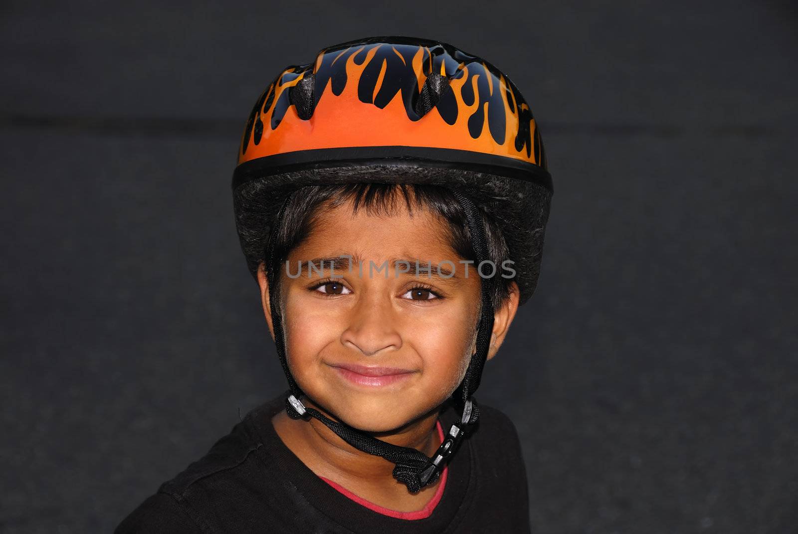 An handsome Indian kid wearing an helmet for safety
