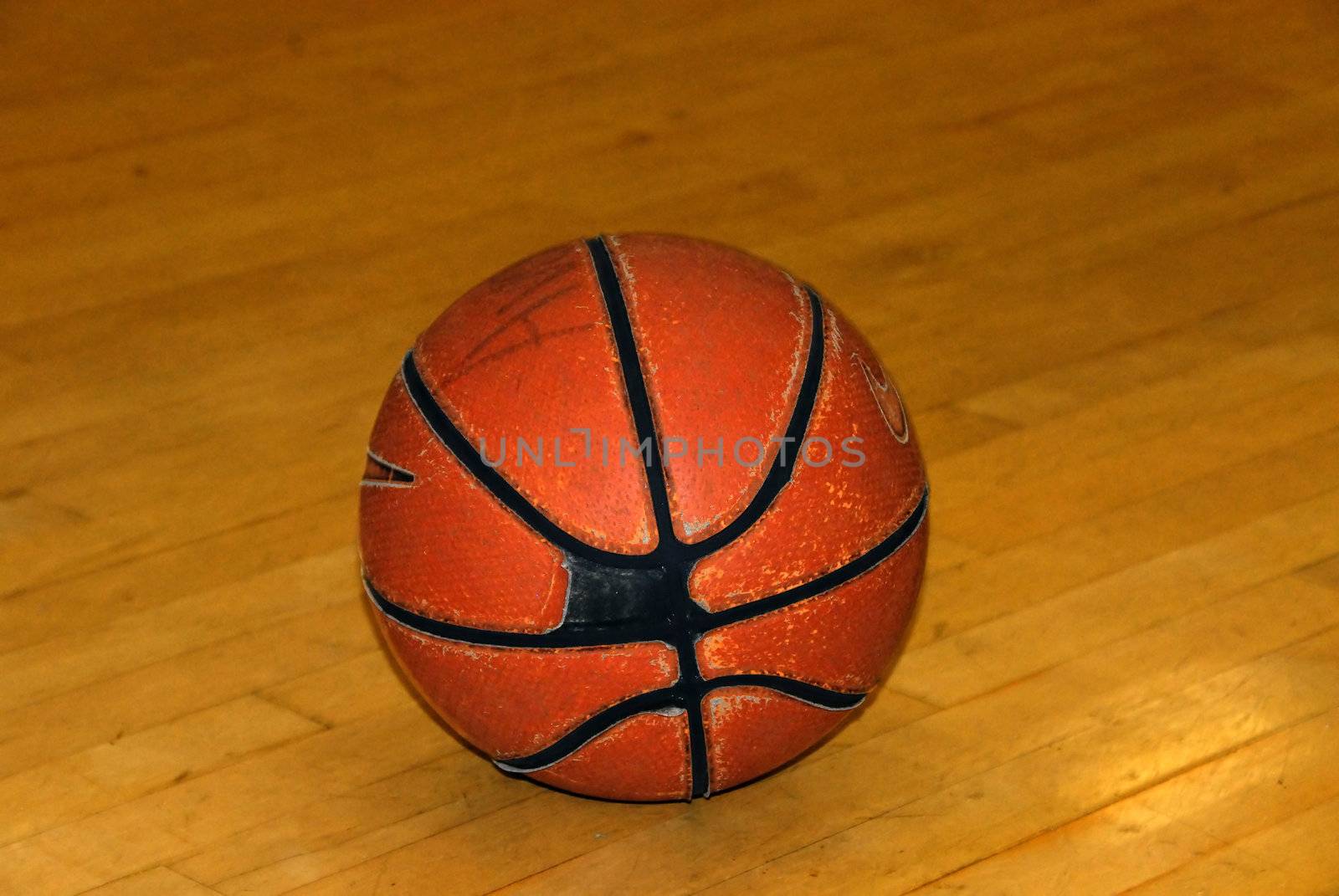 An old worn basketball on an indoor court