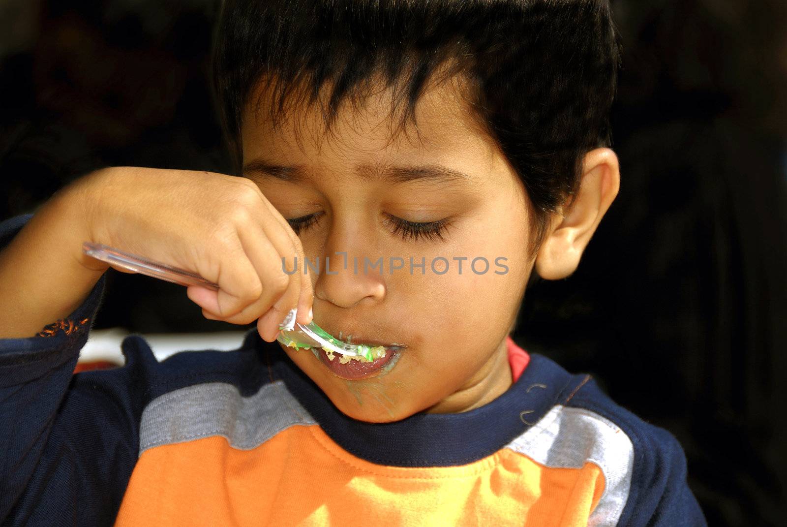 Handsome Indian kid enjoying a birthday cake