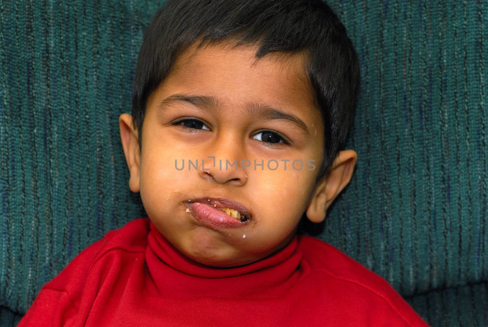 an handsome kid stuffing his mouth with cookies