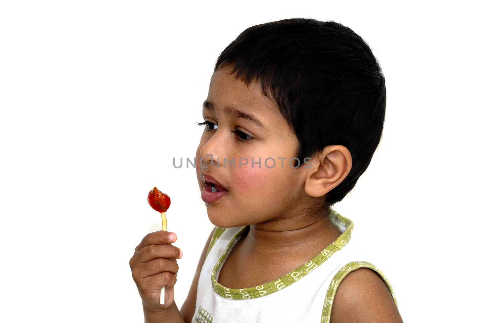 An handsome young Indian kid sucking on a lollypop