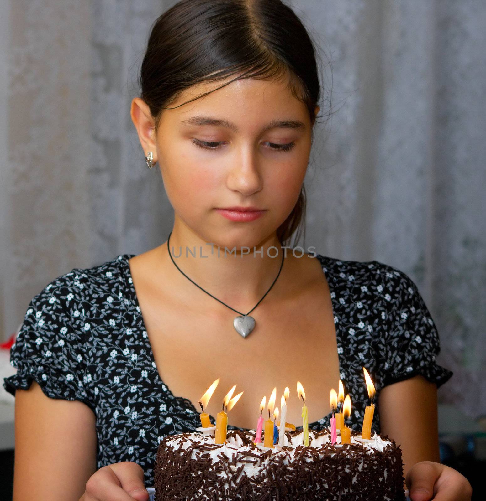 The happy girl holds in hands a celebratory cake with candles