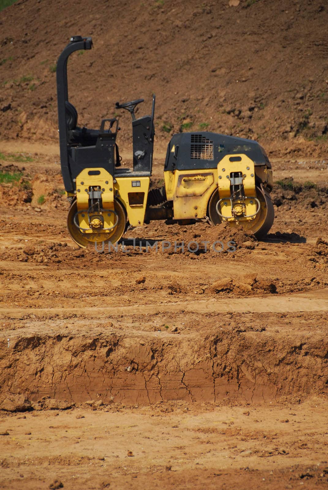 Photo of heavy roller from profile, spoil heap in the background.
