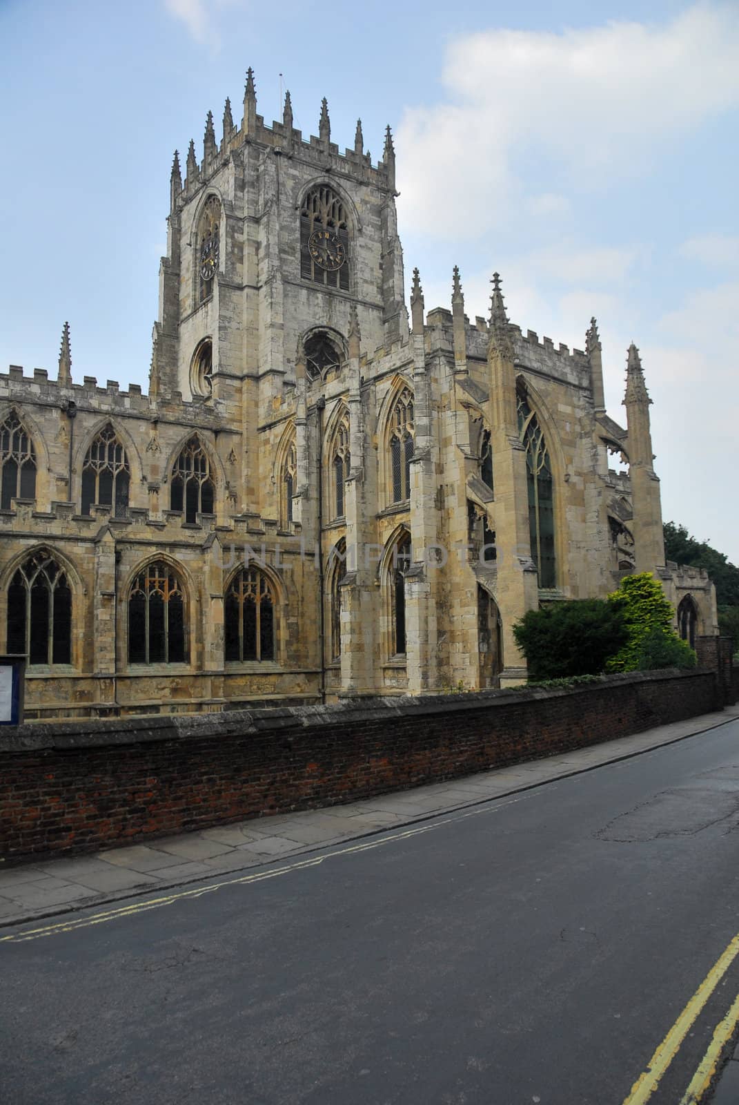 Gothic church under blue sky. Situated next to the road.