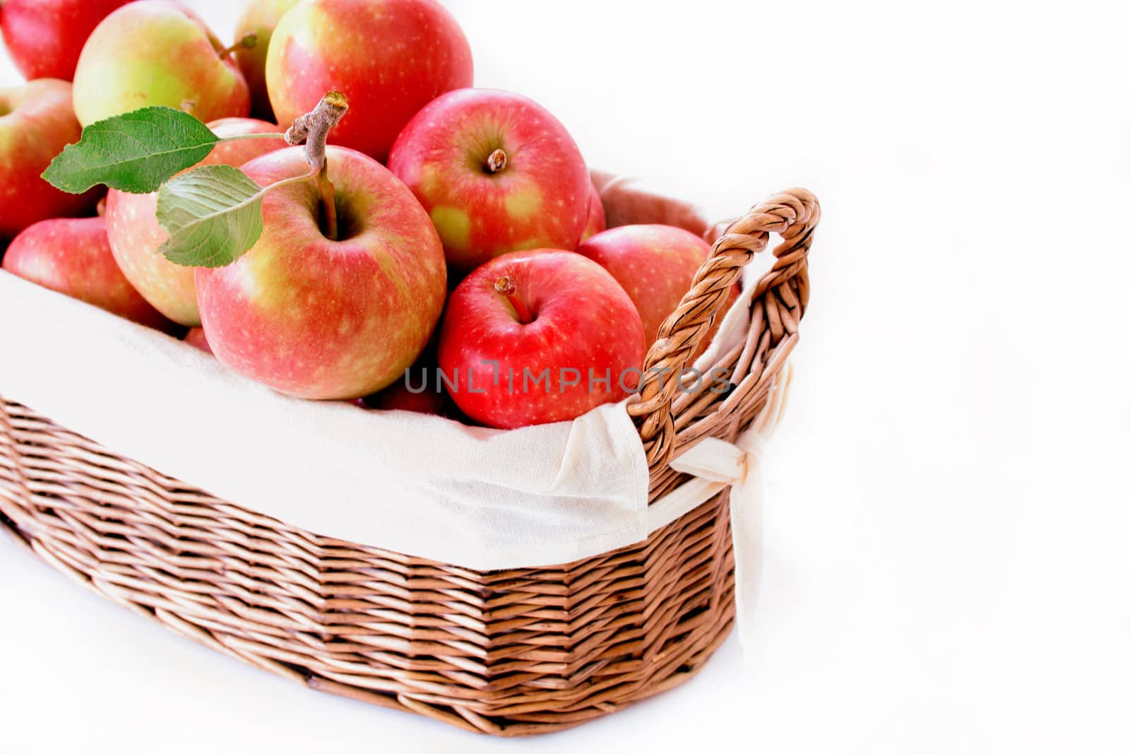 A basket of fresh picked apples isolated on white.