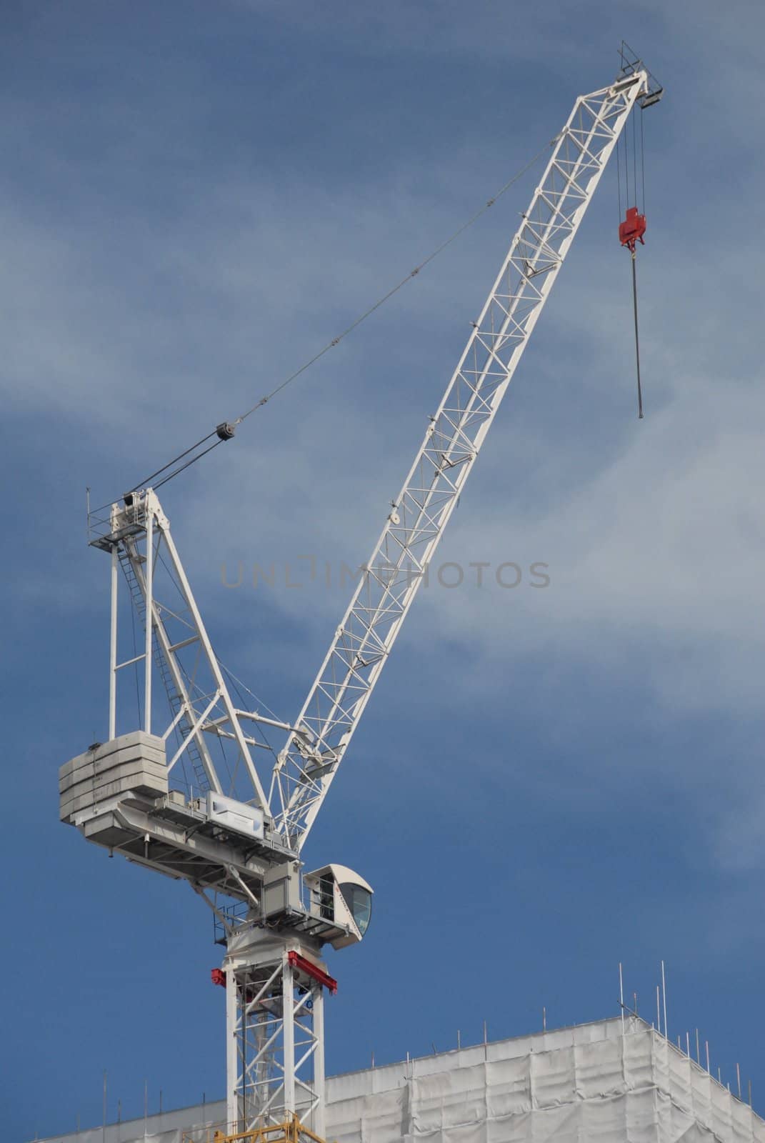White crane stands out from the sky but corresponds very well with the building. 