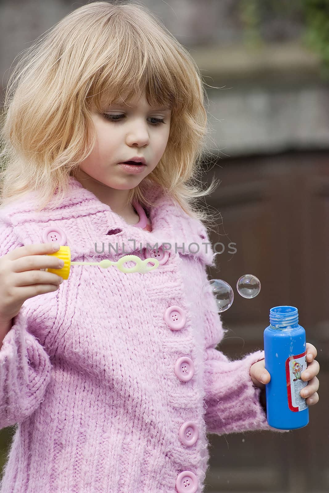 Little girl blowing soap bubbles