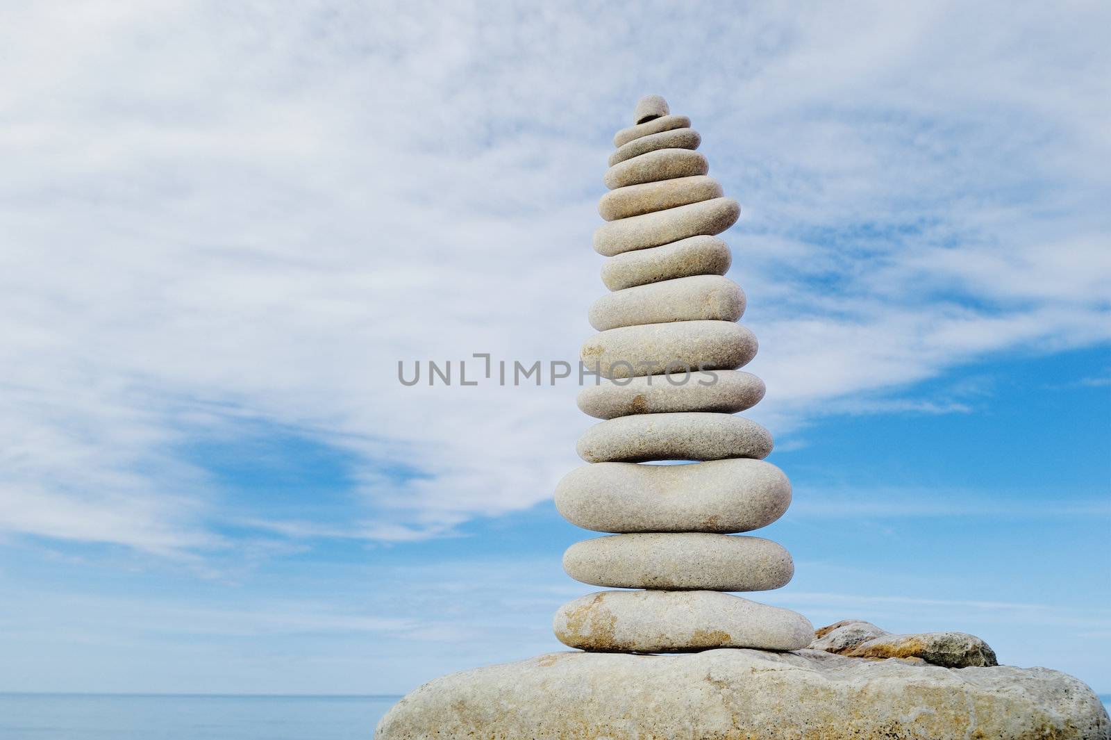 Pile of long pebbles in the balance on the seacoast
