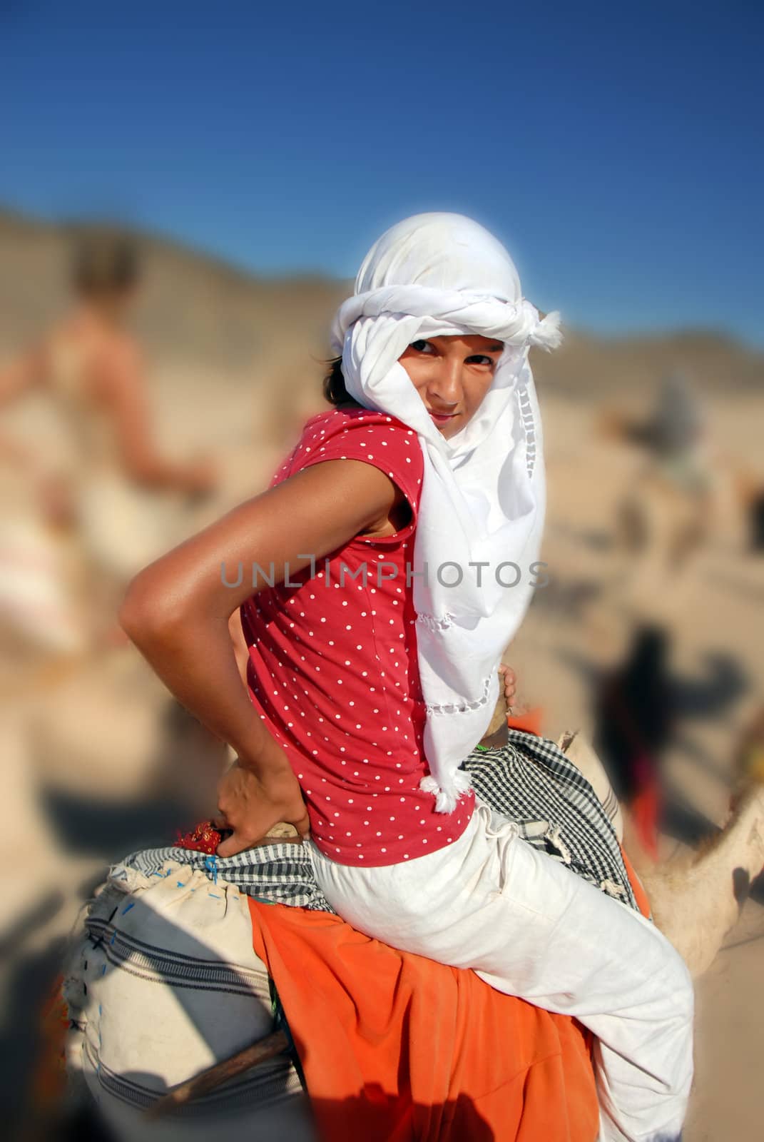 girl tourist in white kerchief riding camel in egypt