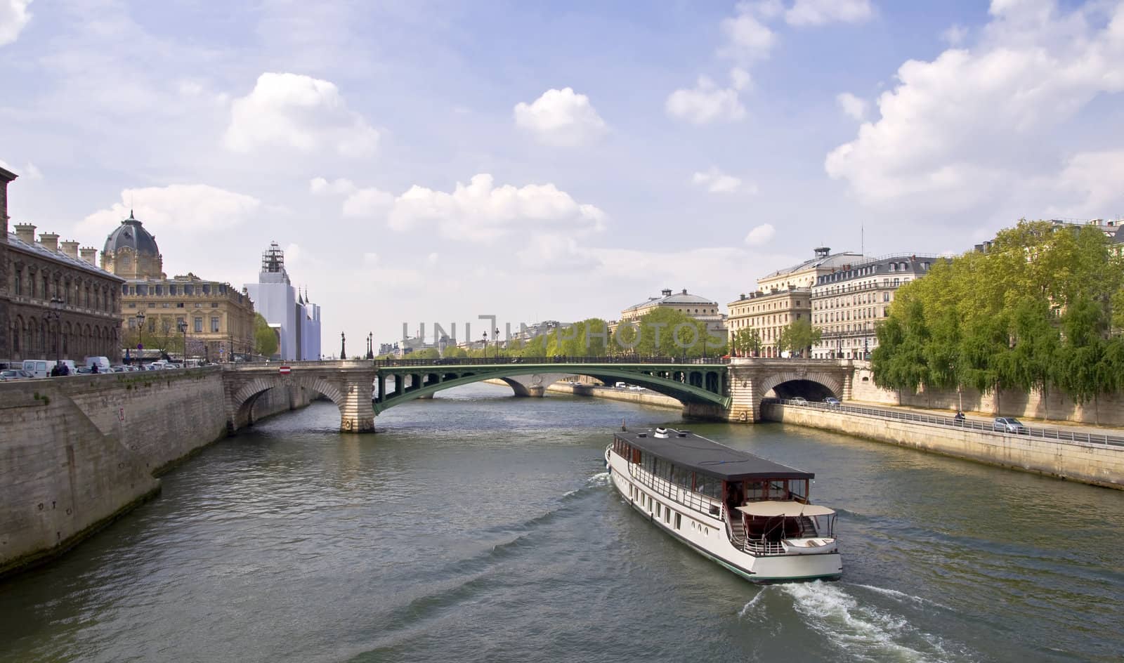 Passenger ship boat sails on the river Seine. View from the Quay. Urban scene. Paris